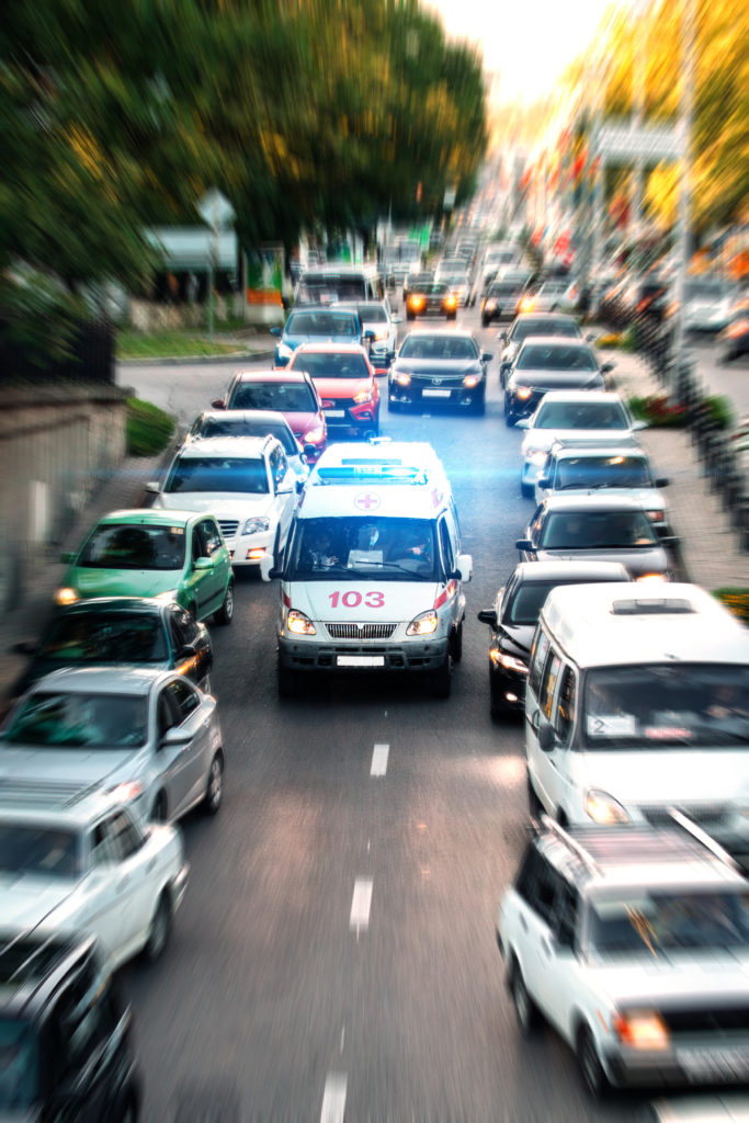an ambulance rushes to a call on the highway through a traffic jam - what to do when an ambulance is behind you