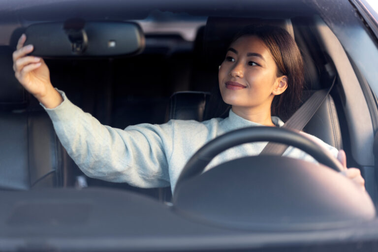 Woman checking her rearview mirror before driving