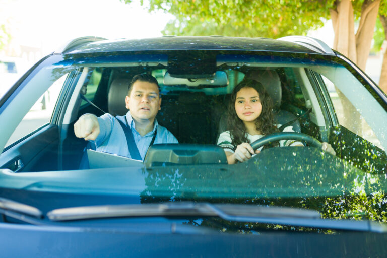 girl doing a mock driving test with her dad